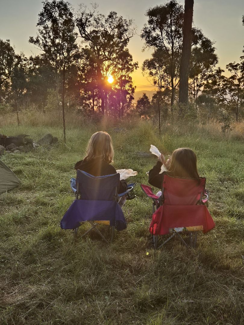 Amelia and Quinn watching a golden sunset through Australian gum trees
