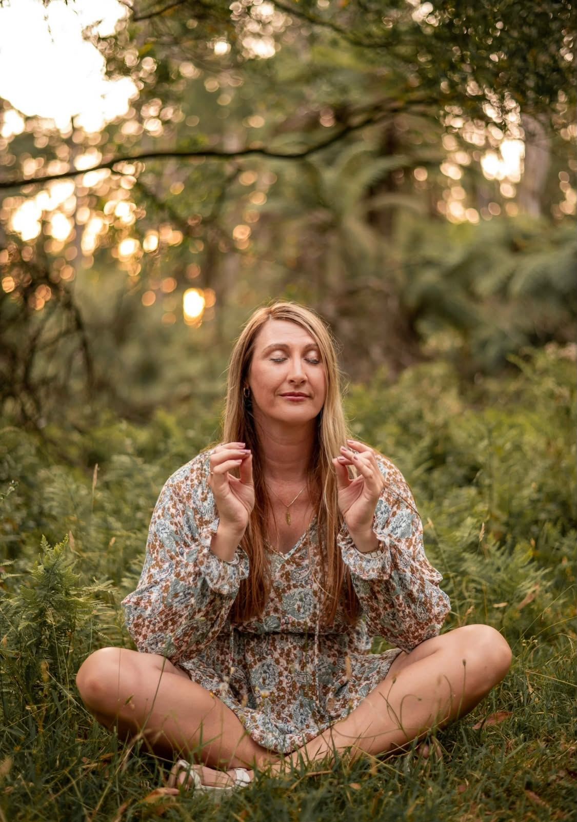 Farrah Buckland meditating cross-legged among ferns