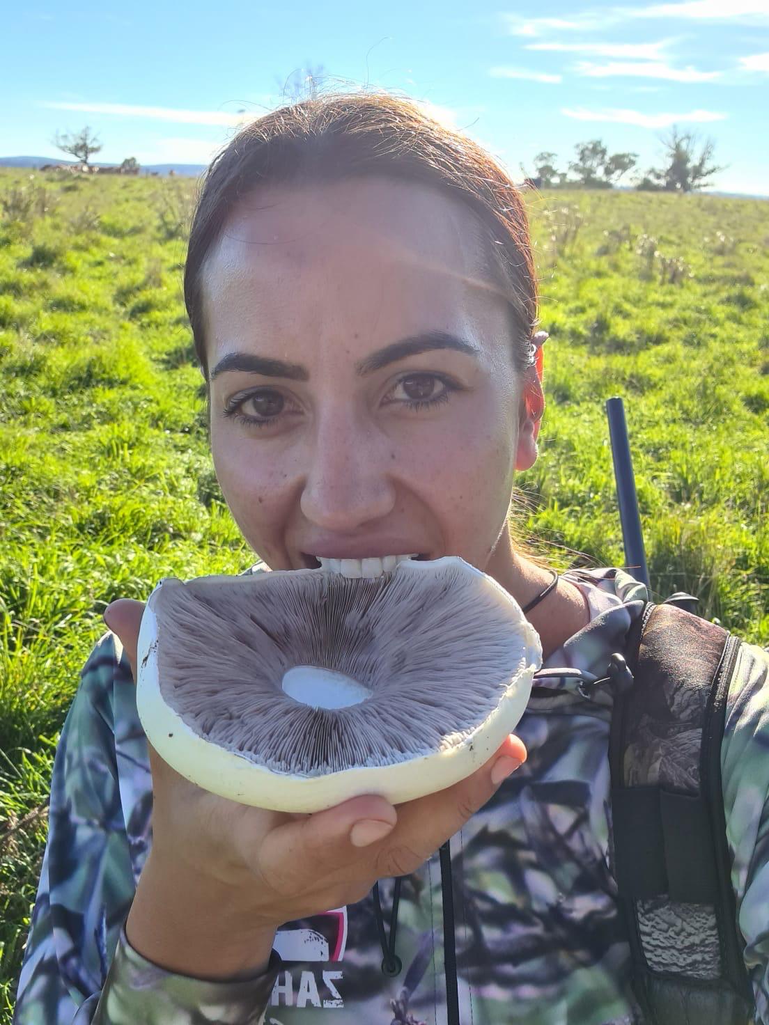Claire holding an enormous field mushroom out in the paddock
