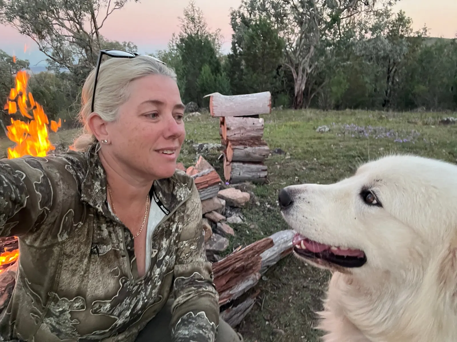 Carly by the fire at dusk with her dog, the day winding down