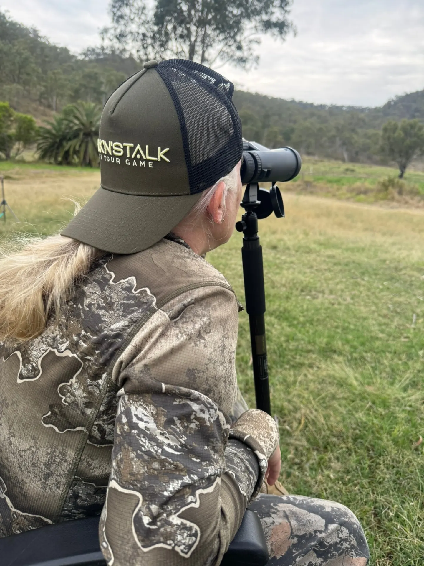 Glassing through binoculars across an open paddock, scanning the country